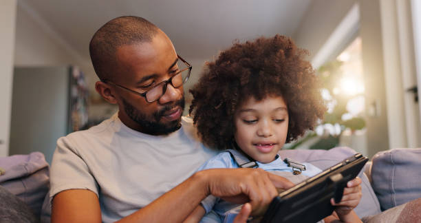 istock Home, dad and boy with tablet on sofa on educational games for learning and entertainment. People, parent and kid on couch in living room with smile for ebooks and streaming platform for cartoons 2163620569