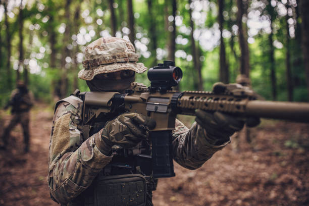 istock Forest-based soldier aiming rifle on patrol mission 2163621134