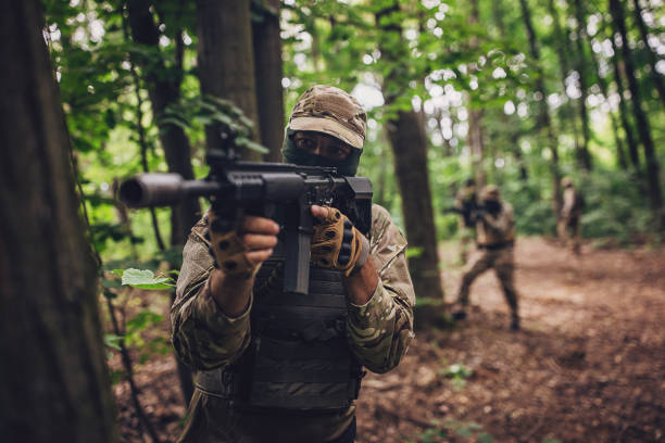 istock Soldier aiming rifle during tactical forest operation. 2163621336