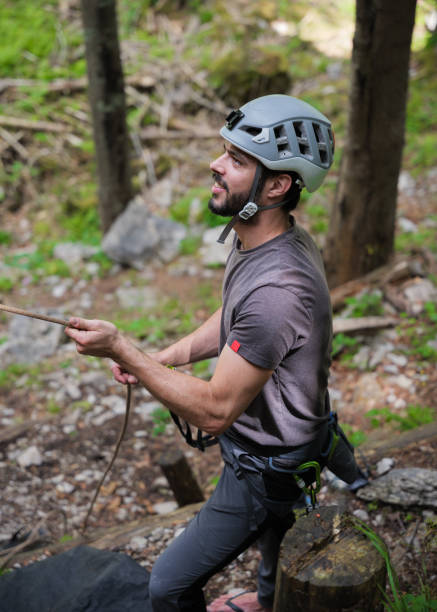 istock Climber wearing helmet and holding rope in forest 2163621699