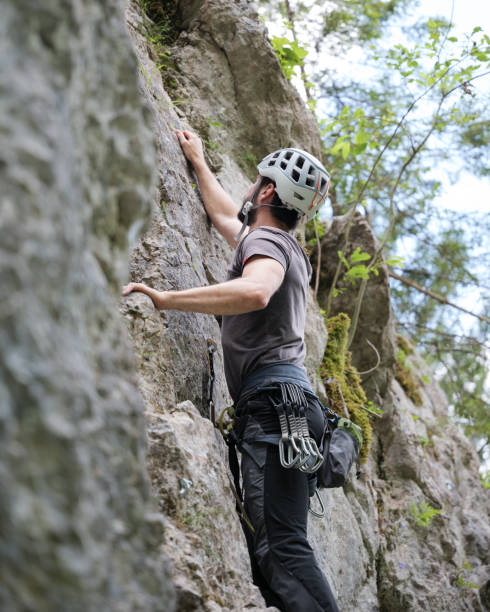 istock Man Climbing Rock Face with helmet 2163621717