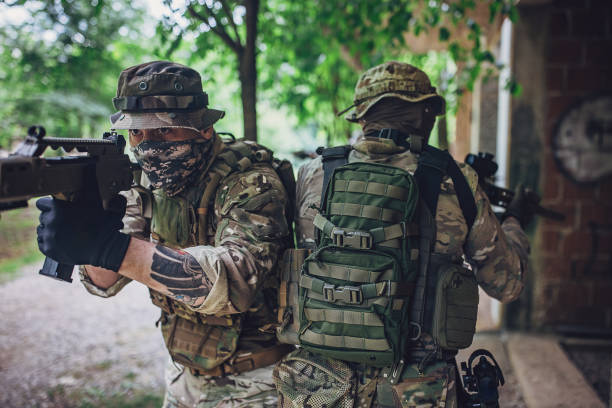 istock Soldiers aiming guns while positioned back-to-back 2163623269