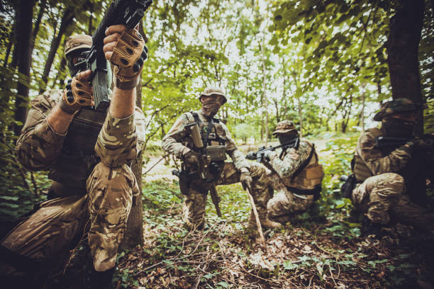 istock Four commando soldiers planning and preparing in forest 2163626584