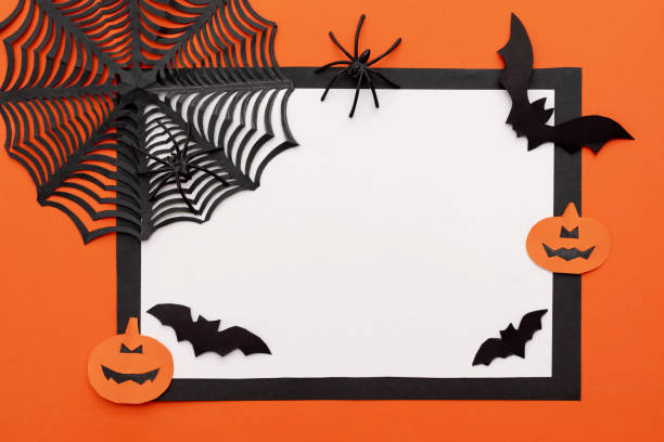istock Halloween greeting card frame for text with black spider web, paper black bats and pumpkins on an orange background. Flat layout with copy space 2163627604