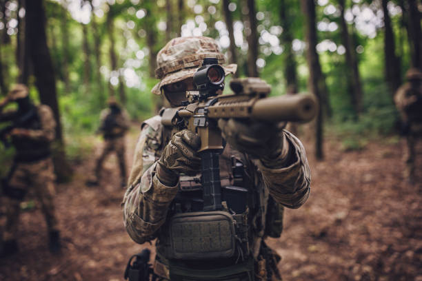 istock Camouflaged soldier aiming rifle with precision scope 2163631796