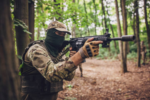 istock Stealthy soldier aiming rifle in forest training. 2163631928