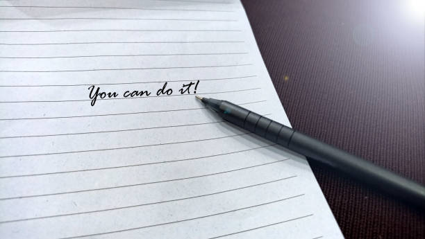 istock Reminder motivational note on white paper with pen - you can do it. 2163632591