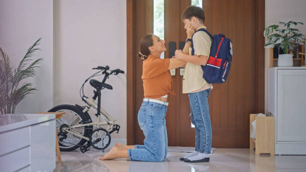 istock A mother talks lovingly with her son before school in the morning at the front door 2163632649