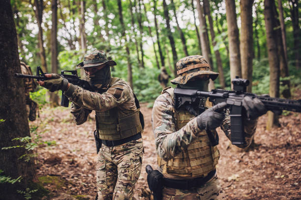 istock Two soldiers aiming guns in forest during operation. 2163632718