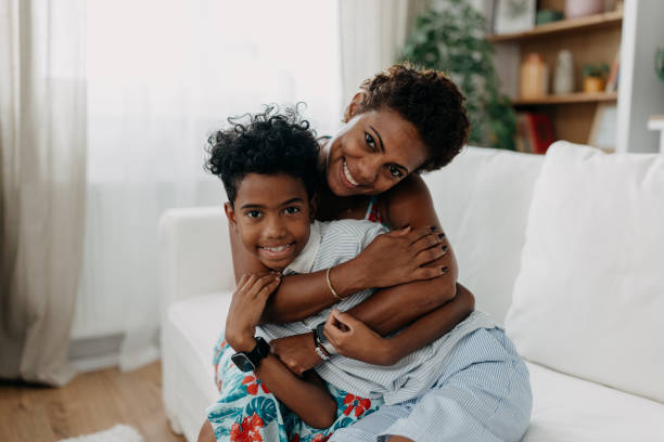 istock Mother hugging child, warm embrace on white sofa 2163634627