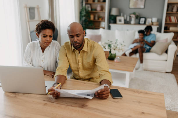 istock Man and woman at table with laptop, reviewing documents 2163635286