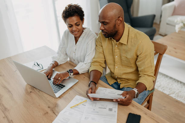istock Focused couple working on budget plans with laptop open 2163635350