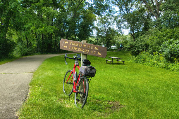 Sunny Summer day landscape of a bike leaning against a mileage marker along the Root River and Harmony-Preston Valley Trails near Lanesboro, Minnesota.