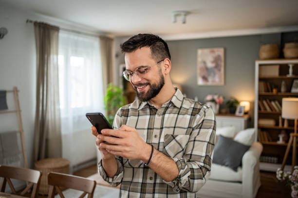 istock Joyful man texting on his cell hone at home 2163642849