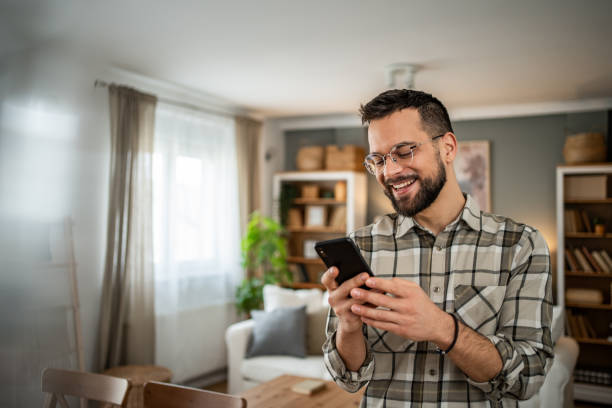 istock Joyful man texting on his cell hone at home 2163642850