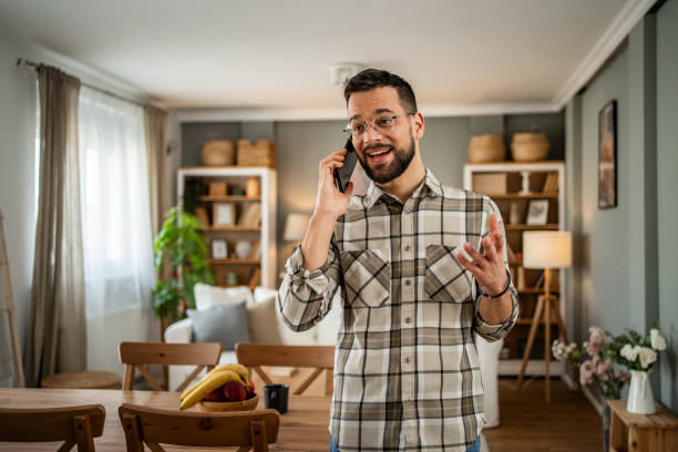 istock A handsome man with a beard is having a pleasant conversation on the phone at home 2163643012
