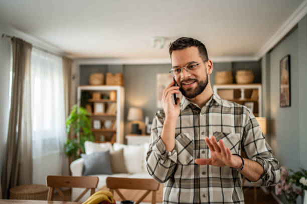 istock A handsome man with a beard is having a pleasant conversation on the phone at home 2163643043