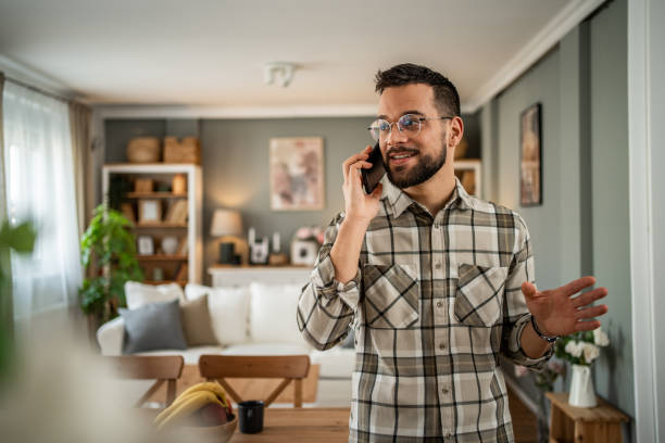 istock A handsome man with a beard is having a pleasant conversation on the phone at home 2163643046