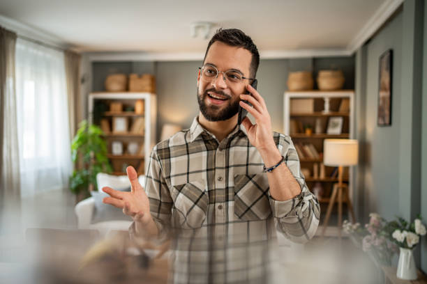 istock A handsome man with a beard is having a pleasant conversation on the phone at home 2163643095