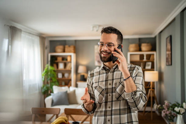 istock A handsome man with a beard is having a pleasant conversation on the phone at home 2163643184