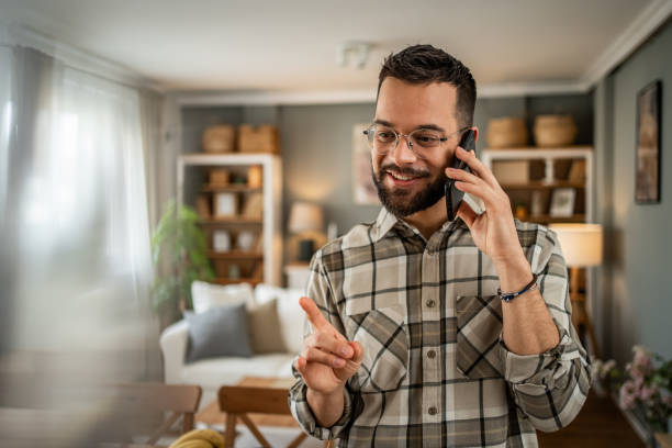 istock A handsome man with a beard is having a pleasant conversation on the phone at home 2163643199