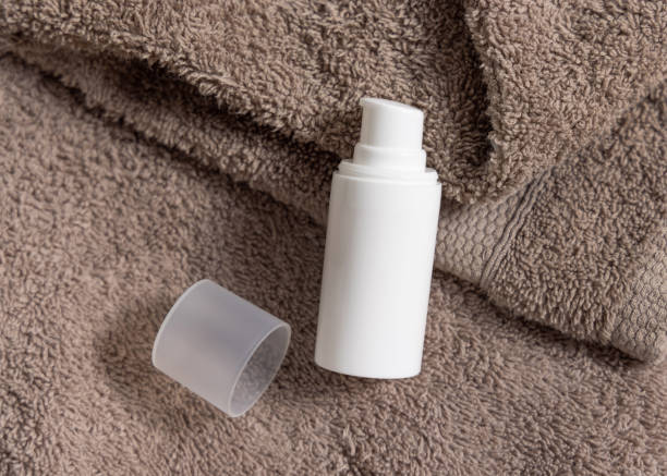 istock White cream pump bottle on brown folded towels top iew, cosmetic packaging mockup 2163643387