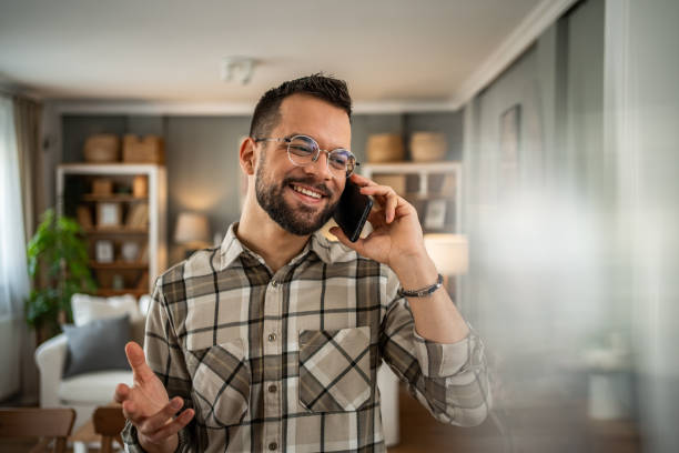 istock A handsome man with a beard is having a pleasant conversation on the phone at home 2163643393