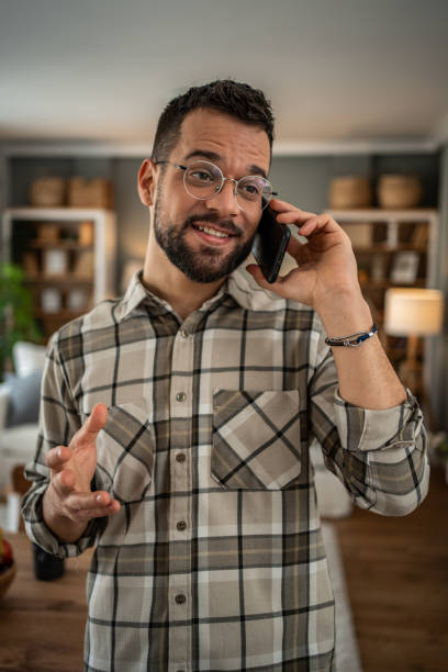 istock A handsome man with a beard is having a pleasant conversation on the phone at home 2163643395