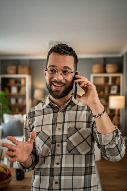 istock A handsome man with a beard is having a pleasant conversation on the phone at home 2163643455