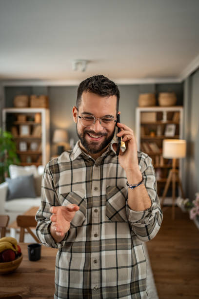 istock A handsome man with a beard is having a pleasant conversation on the phone at home 2163643458