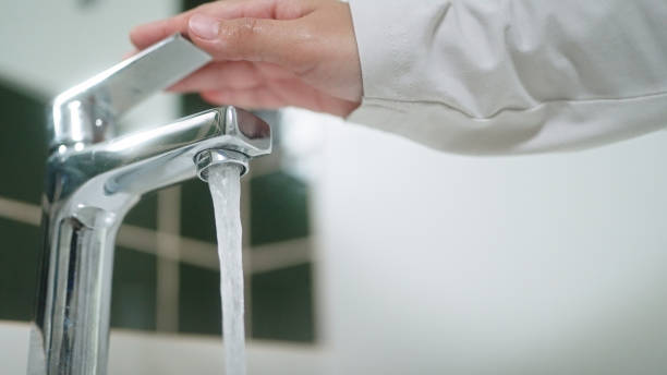 istock Turning on or off faucet in bathroom. 2163644225