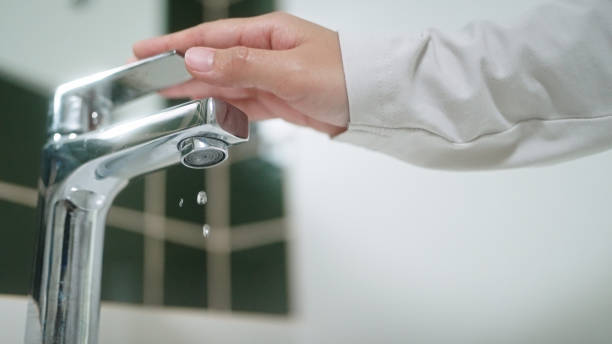 istock Turning on or off faucet in bathroom. 2163644228