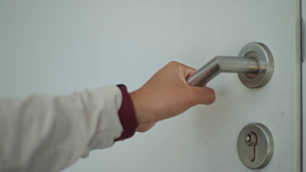 istock Hand holding a door knob and opening go to inside. 2163644252