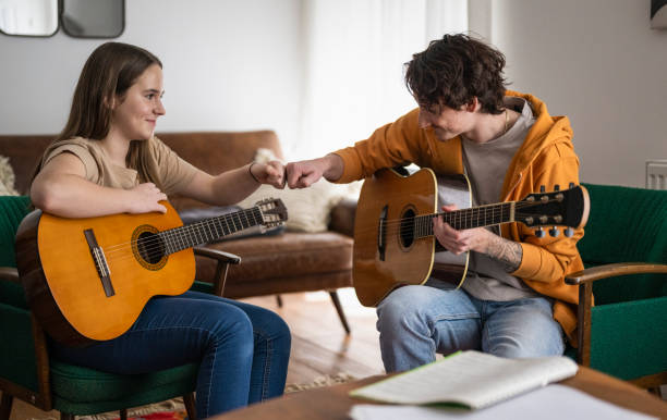 istock Young Guitar Instructor Gives Private Lesson To Female Student 2163648935