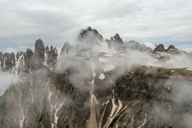 Tre Cime Circuit Trail: Snow and fog weave around the majestic Dolomites, creating a mystical scene