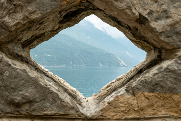 The serene waters of Lago di Garda reflect the grandeur of the surrounding mountains, creating a picturesque harmony of lake and peak