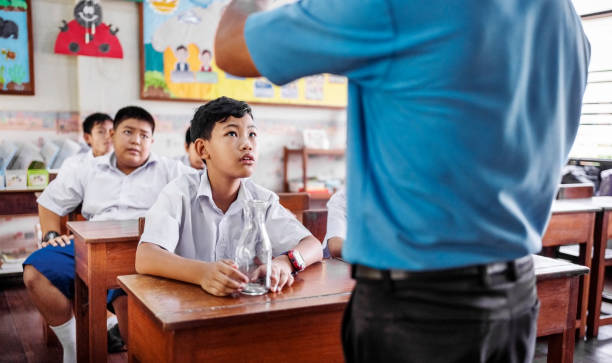School classroom with students sitting at their desks and paying close attention to the teacher during science class