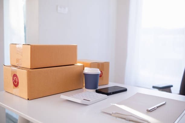 istock parcel boxes being packaged and ready to be sent to customers who have placed online orders within the online store's system. A small SME businessman has prepared the parcels and is ready for delivery 2163658606