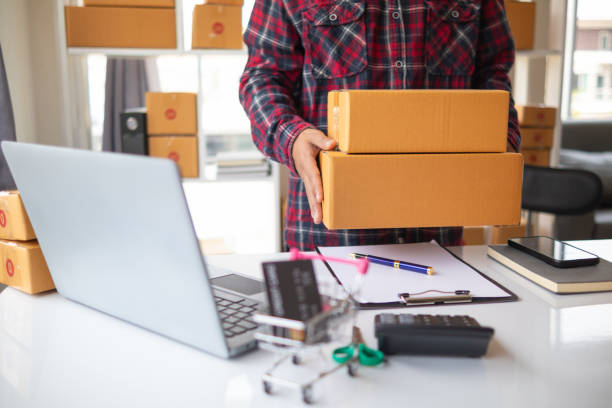 istock parcel boxes being packaged and ready to be sent to customers who have placed online orders within the online store's system. A small SME businessman has prepared the parcels and is ready for delivery 2163658651