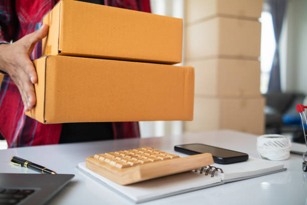 istock parcel boxes being packaged and ready to be sent to customers who have placed online orders within the online store's system. A small SME businessman has prepared the parcels and is ready for delivery 2163658750