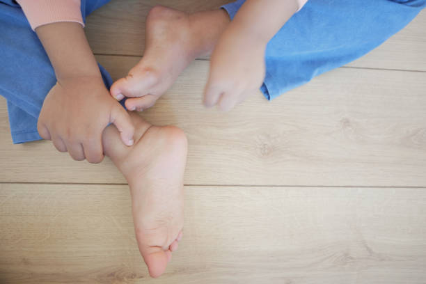 a kid suffering from itching skin on feet .