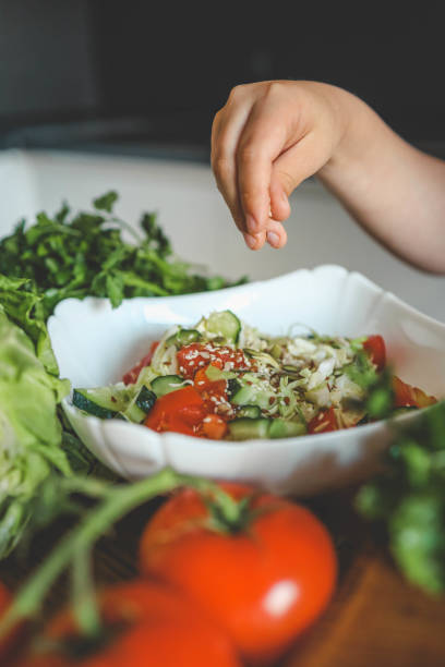 istock Preparing vegetable salad, sprinkle flax and sesame seeds 2163659453