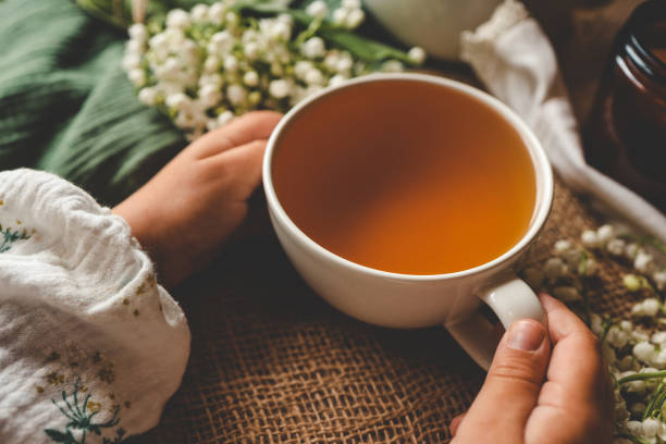 istock Cup of herbal tea in hands, spring atmosphere mood 2163659609
