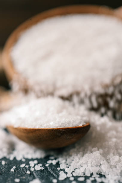 istock Pour salt into a wooden spoon, close-up 2163661935