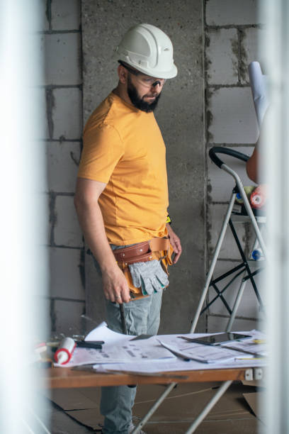istock Construction worker examining architectural blueprints on the table in the apartment under construction 2163664151