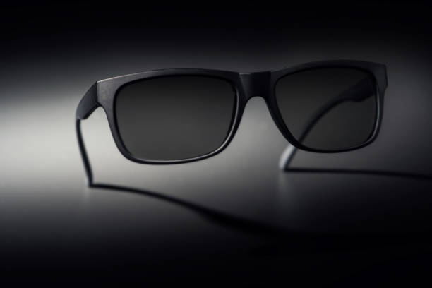 istock Matte black sunglasses on a gradient background, blending dark and light tones, creating a modern and stylish look 2163664223