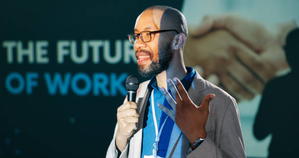 istock Conference, speech for work future and man with microphone on stage for business seminar or workshop. Corporate, development and training with speaker on stage for presentation or public speaking 2163665278