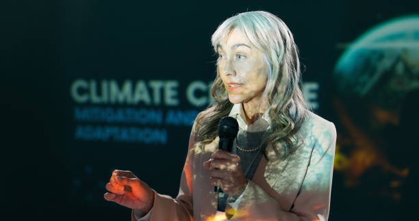 istock Conference, mature woman and seminar on stage for speech, talk or discussion with workshop host. Panel, mic and expert at forum event for presentation on environment, climate change or sustainability 2163665289