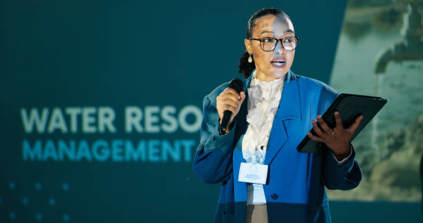 istock Conference, woman and seminar on stage for speech, talk or discussion for workshop host. Panel, mic and expert at speaker event for presentation on water management, sustainability or renewable forum 2163665292