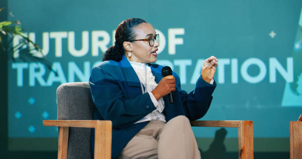 istock Conference, woman and speaker on stage for talk, speech or discussion with workshop host. Panel, mic and expert at seminar event for presentation on transport, sustainability or renewable energy 2163665331